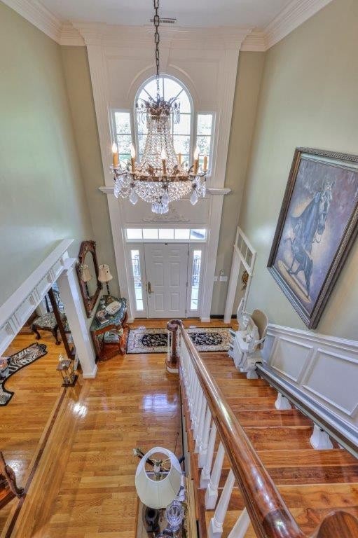 entryway featuring a chandelier, ornamental molding, and hardwood / wood-style flooring