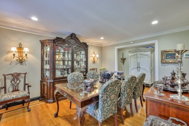 dining room with crown molding and light hardwood / wood-style floors