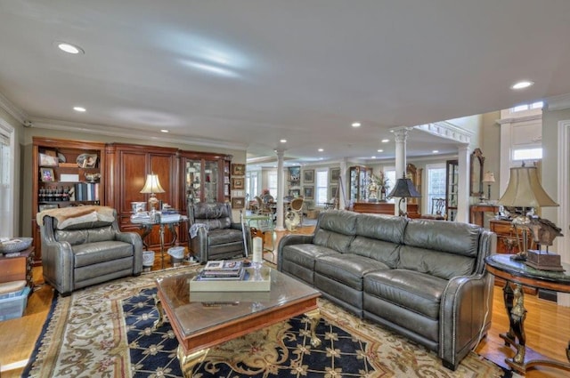 living room with hardwood / wood-style floors, decorative columns, and ornamental molding