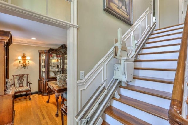 stairway with crown molding and hardwood / wood-style flooring