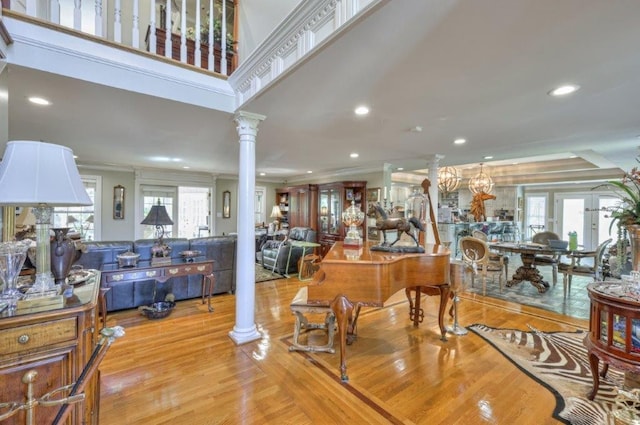 dining space with french doors, ornamental molding, ornate columns, and light hardwood / wood-style floors