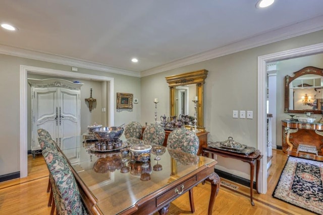 dining space with light hardwood / wood-style flooring and ornamental molding