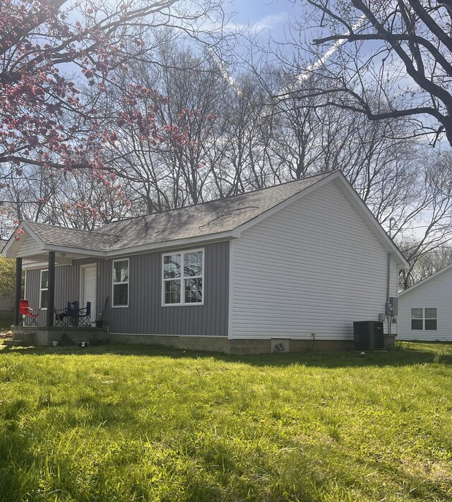 view of property exterior with cooling unit and a yard