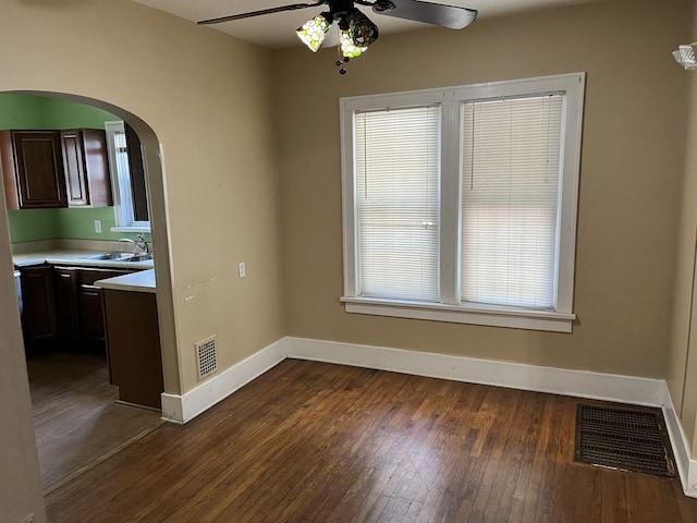 unfurnished room featuring ceiling fan, sink, and dark hardwood / wood-style flooring