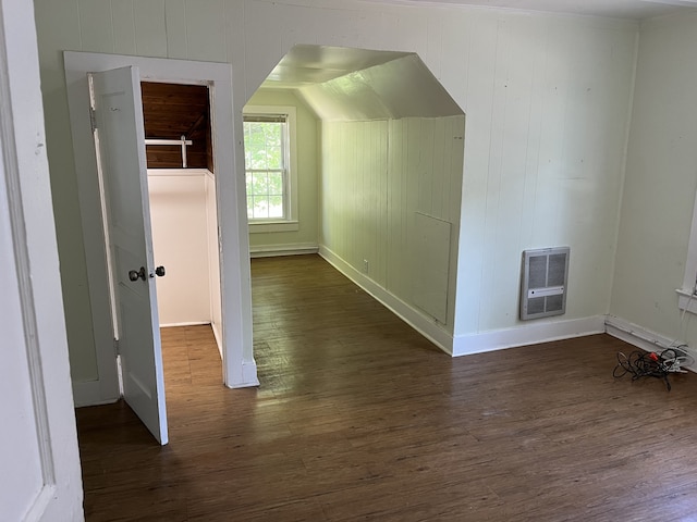 additional living space with lofted ceiling, heating unit, and dark hardwood / wood-style floors