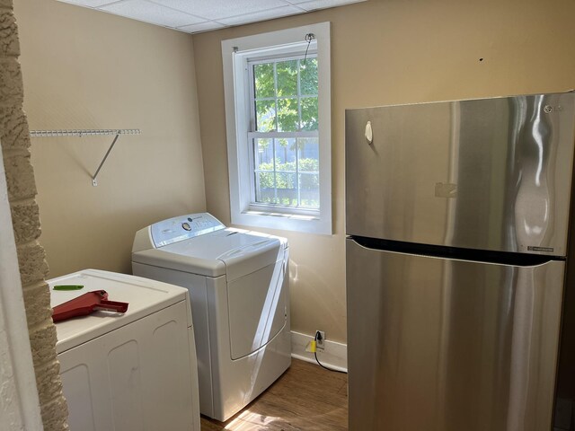 laundry area featuring washing machine and dryer and wood-type flooring