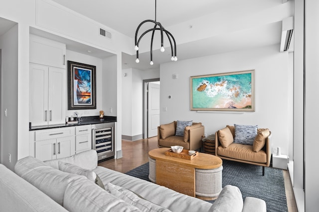 living room with dark hardwood / wood-style flooring, a chandelier, and beverage cooler