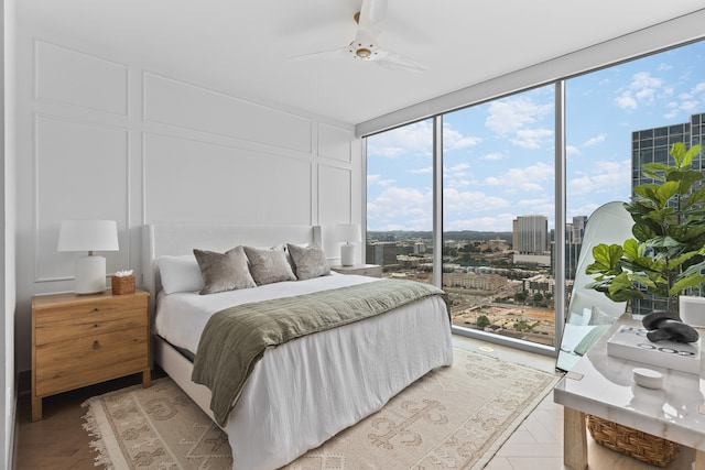 bedroom with ceiling fan, access to exterior, and expansive windows