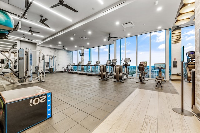 workout area featuring floor to ceiling windows, light wood-type flooring, and ceiling fan