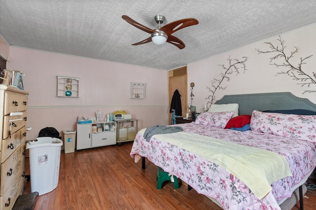 bedroom with hardwood / wood-style flooring, a textured ceiling, and ceiling fan