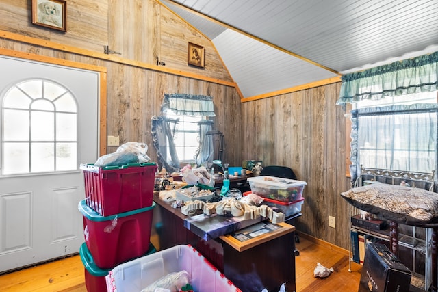 interior space featuring lofted ceiling, plenty of natural light, hardwood / wood-style flooring, and wooden walls