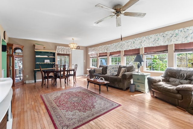 living room featuring ceiling fan with notable chandelier, a healthy amount of sunlight, and light hardwood / wood-style floors