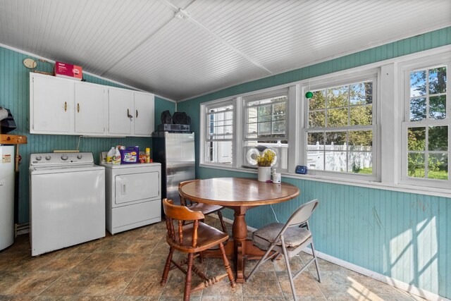 laundry room featuring cabinets, water heater, dark tile patterned floors, and independent washer and dryer