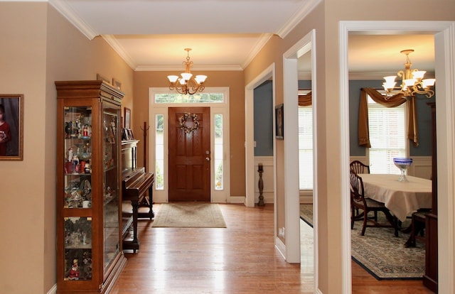 foyer entrance with light hardwood / wood-style floors, plenty of natural light, and an inviting chandelier