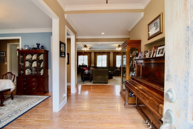 entrance foyer featuring light wood-type flooring, crown molding, and ceiling fan