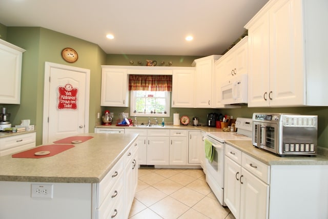 kitchen featuring a kitchen island, light tile patterned floors, white appliances, and white cabinetry