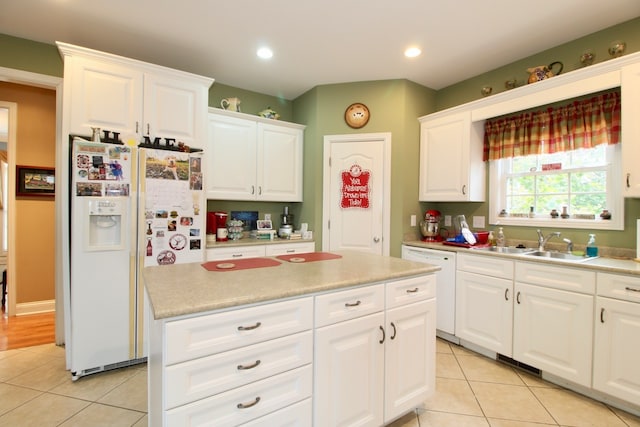 kitchen featuring light tile patterned floors, a center island, white appliances, white cabinetry, and sink