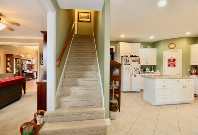 stairway featuring ceiling fan, indoor bar, crown molding, and tile patterned floors