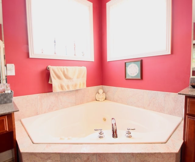 bathroom with vanity and tiled bath