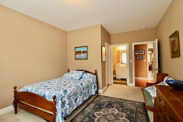 bedroom with ensuite bath and carpet floors