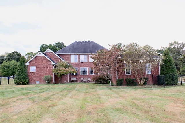 rear view of property with a lawn