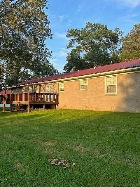 rear view of property with a yard and a deck