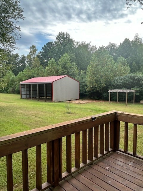 wooden terrace featuring an outdoor structure and a yard