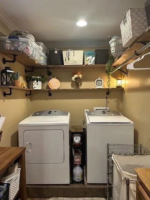 laundry room with crown molding and washing machine and clothes dryer