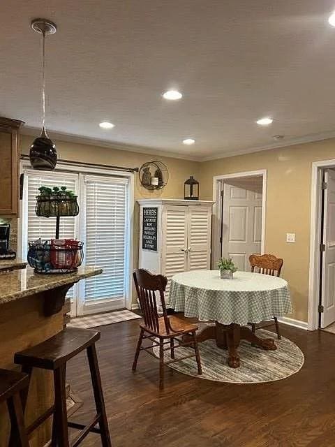 dining space featuring crown molding and dark hardwood / wood-style floors