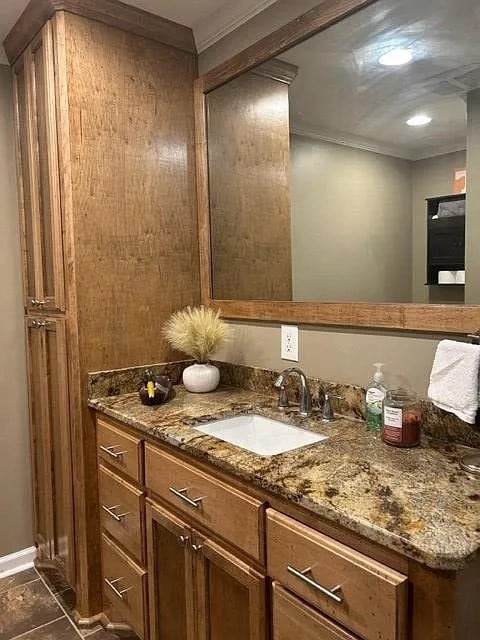 bathroom with tile patterned floors, vanity, and crown molding