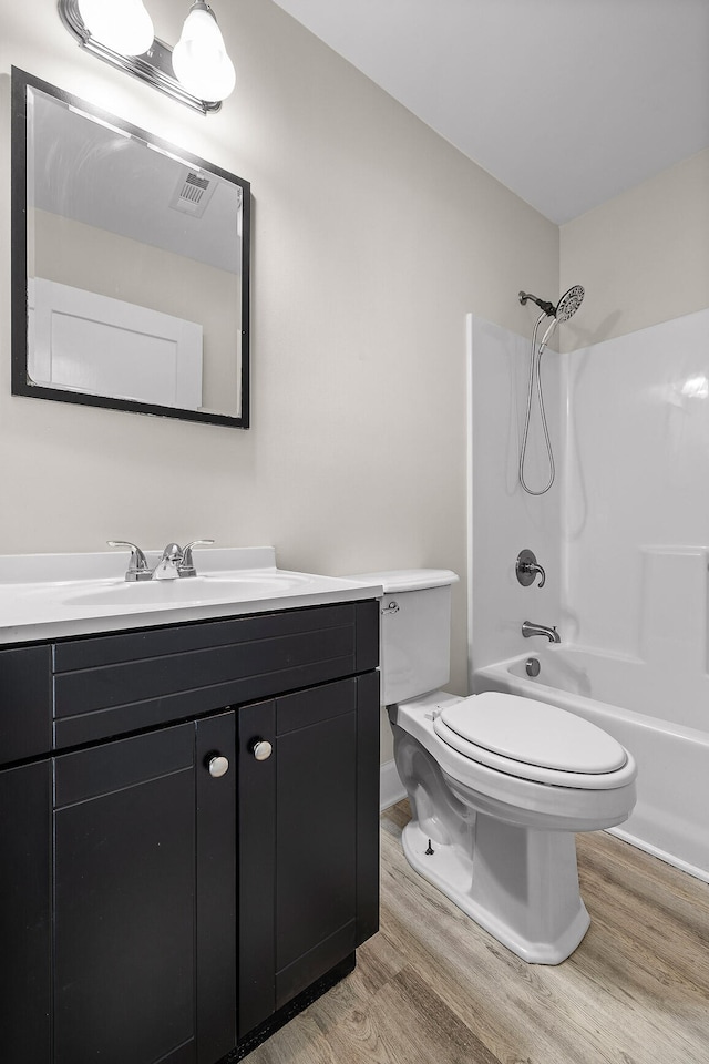 full bathroom featuring vanity, tub / shower combination, toilet, and hardwood / wood-style flooring