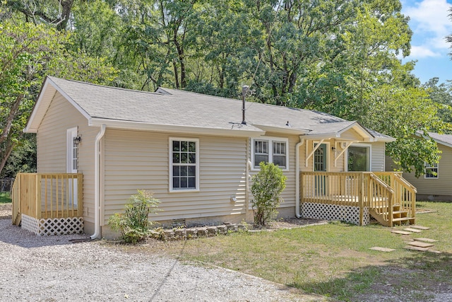 ranch-style house with a front lawn and a wooden deck