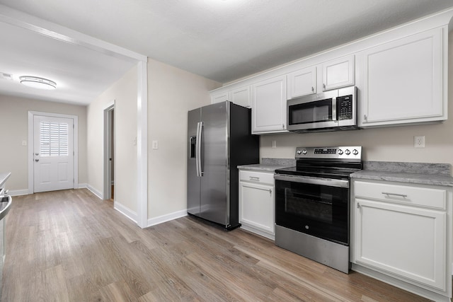 kitchen with appliances with stainless steel finishes, light hardwood / wood-style flooring, and white cabinetry