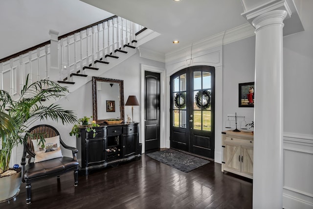 foyer with decorative columns, french doors, dark hardwood / wood-style flooring, and ornamental molding