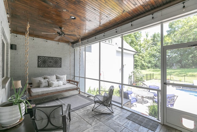 sunroom / solarium with ceiling fan and wooden ceiling