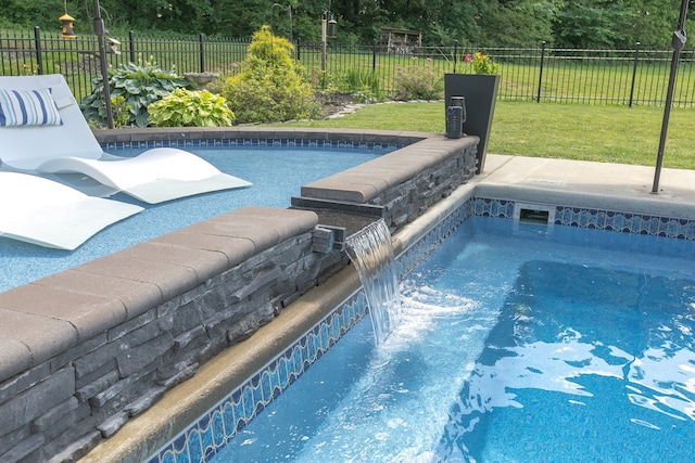 view of swimming pool featuring a lawn and pool water feature