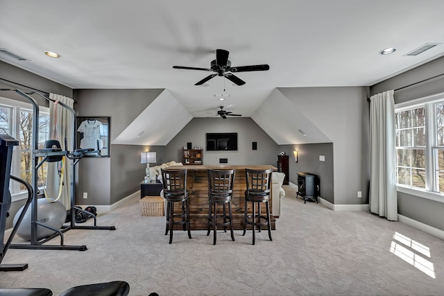 interior space featuring bar area, lofted ceiling, ceiling fan, and a wealth of natural light