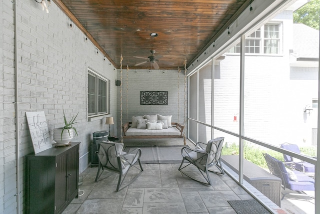 sunroom / solarium featuring ceiling fan, wooden ceiling, and plenty of natural light