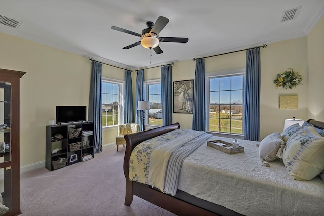 bedroom featuring ceiling fan, ornamental molding, multiple windows, and carpet