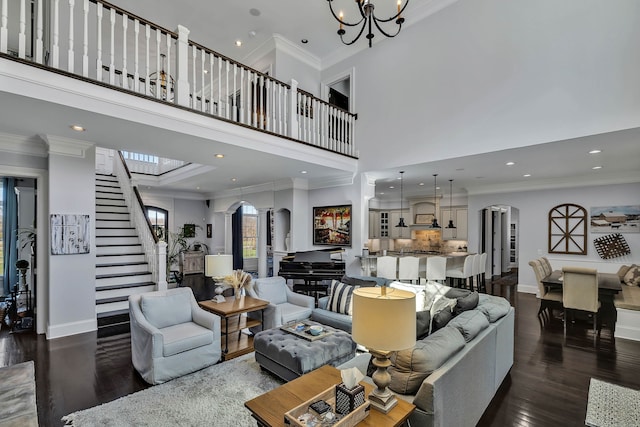 living room with crown molding, dark hardwood / wood-style flooring, a chandelier, and a high ceiling