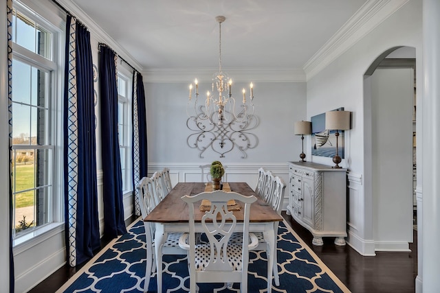 dining area featuring crown molding, dark hardwood / wood-style floors, and an inviting chandelier