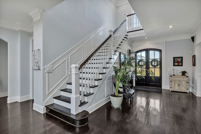 entryway featuring crown molding, french doors, dark hardwood / wood-style flooring, and a high ceiling