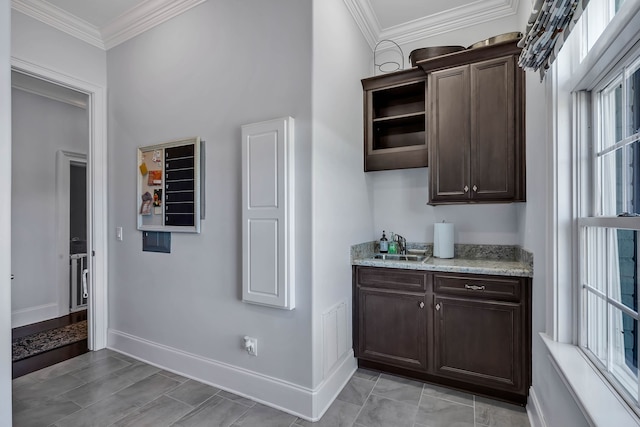 kitchen featuring dark brown cabinetry, ornamental molding, light tile patterned flooring, and light stone countertops