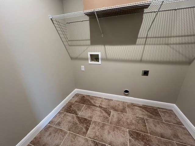 washroom featuring dark tile patterned flooring, hookup for an electric dryer, and hookup for a washing machine