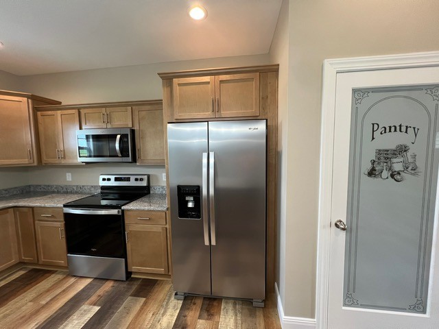 kitchen featuring stainless steel appliances and dark hardwood / wood-style flooring