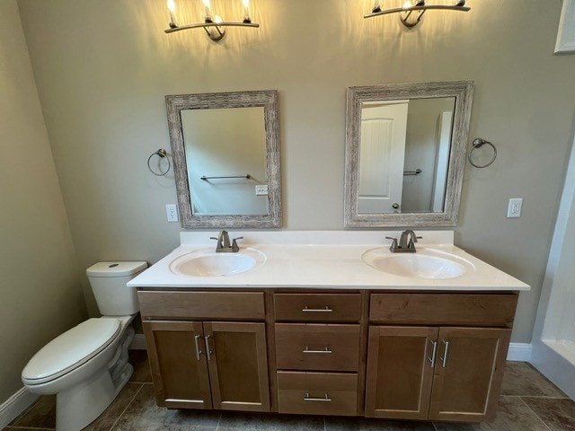 bathroom with double sink vanity, toilet, and tile patterned floors