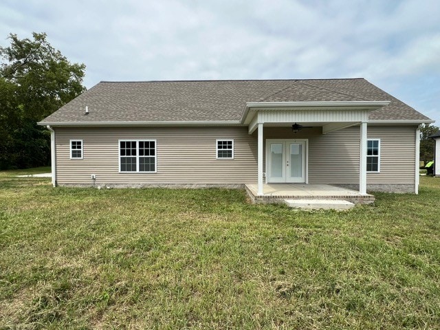 rear view of property with ceiling fan, a patio, french doors, and a lawn