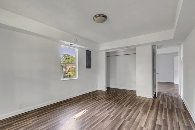 unfurnished bedroom with dark wood-type flooring and a closet