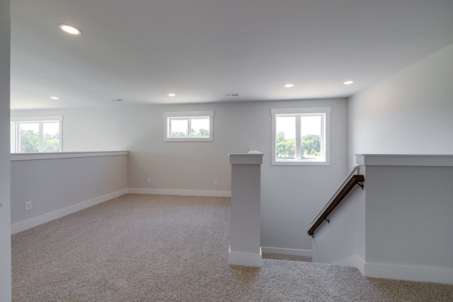 empty room with a wealth of natural light and carpet flooring