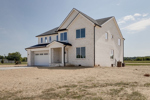 view of front of property featuring a garage and central AC unit